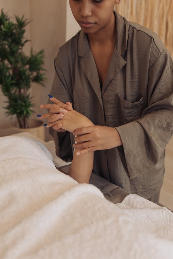 Masseuse Massaging Woman's Hand